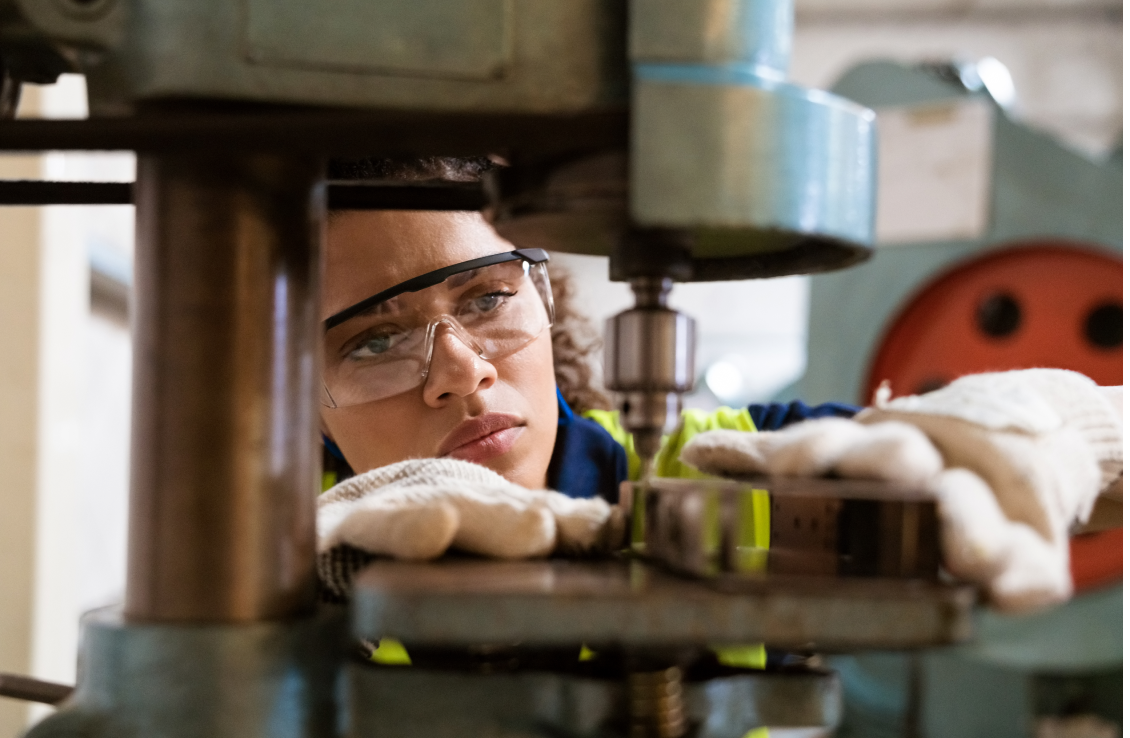 female factory worker inspecting machinery